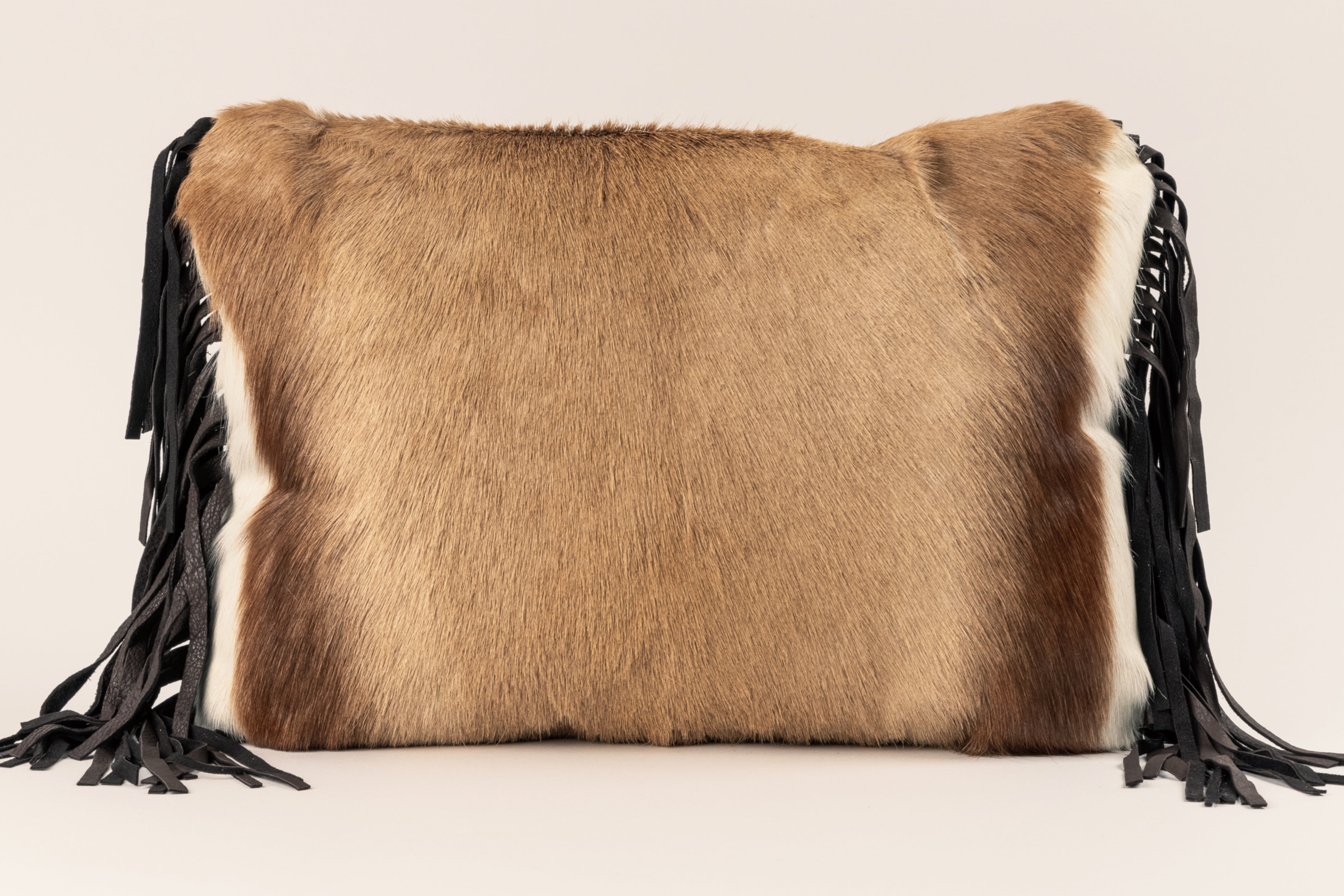 Springbok fur front with fabric back and brown fringe.